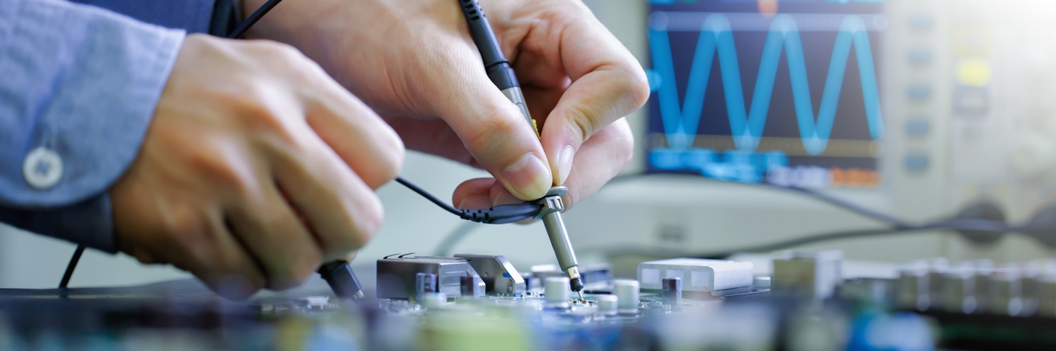 Técnico midiendo una placa electrónica con sondas junto a un osciloscopio