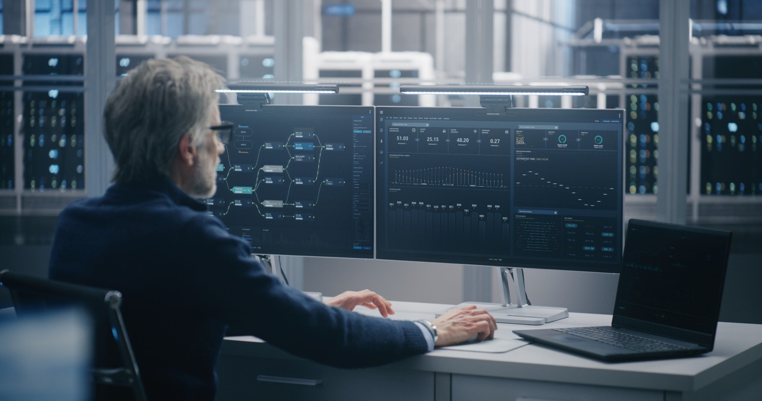 Ingeniero supervisando métricas de sistemas en varios monitores