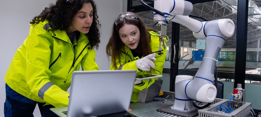 Dos ingenieras programando un brazo robótico colaborativo